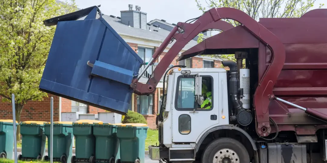 a truck loading a garbage container for waste management company