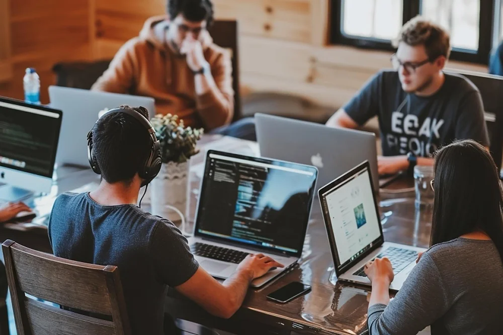 Hire dedicated software developers collaborating on code review as a cohesive dedicated software development team in a modern office environment.